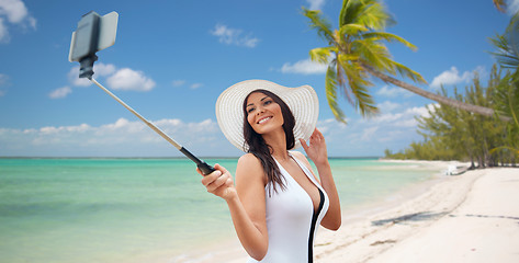 Image showing happy woman taking selfie with smartphone on beach