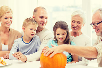 Image showing happy family sitting with pumpkins at home