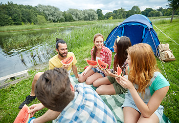 Image showing happy friends eating watermelon at camping