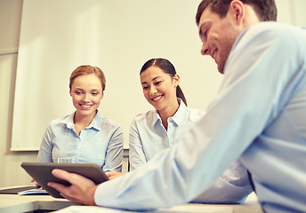 Image showing smiling businesspeople with tablet pc in office