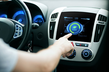 Image showing male hand setting car eco system mode on screen