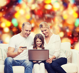 Image showing happy family with laptop computer and credit card