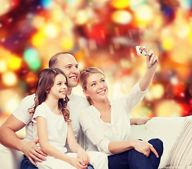 Image showing happy family with camera at home