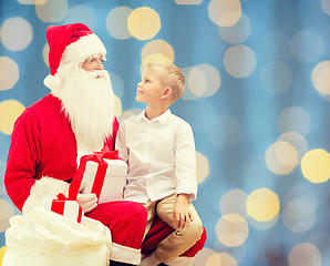 Image showing smiling little boy with santa claus and gifts