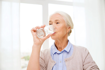 Image showing happy senior woman with glass of water at home