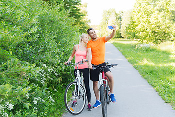 Image showing couple with bicycle and smartphone taking selfie