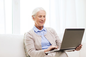 Image showing happy senior woman with laptop at home