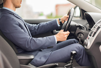 Image showing close up of young man in suit driving car