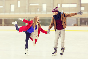 Image showing happy couple holding hands on skating rink