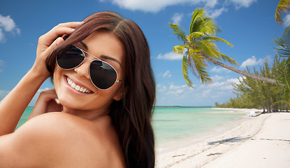 Image showing smiling young woman with sunglasses on beach