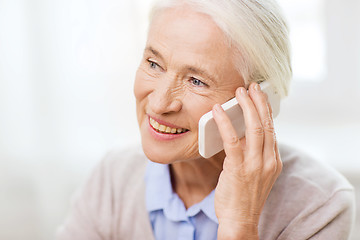 Image showing senior woman with smartphone calling at home