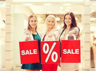 Image showing happy young women with shopping bags in mall