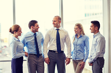 Image showing smiling business people talking in office