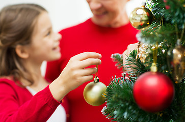 Image showing close up of happy family decorating christmas tree