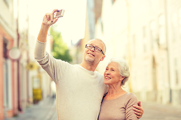 Image showing senior couple photographing on city street