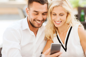 Image showing happy couple with smartphone at city street cafe