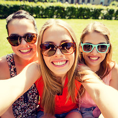Image showing group of smiling teen girls taking selfie in park