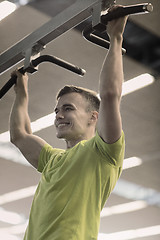 Image showing smiling man exercising in gym