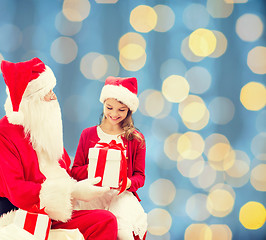 Image showing smiling little girl with santa claus and gifts