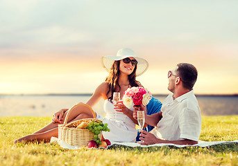 Image showing smiling couple drinking champagne on picnic