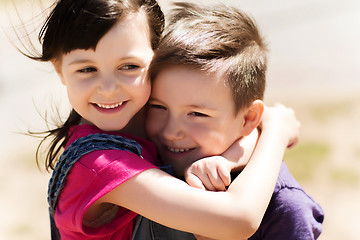 Image showing two happy kids hugging outdoors