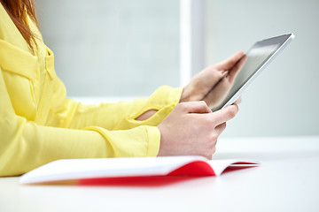 Image showing close up of female hands with tablet pc at table