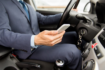 Image showing close up of man with smartphone driving car