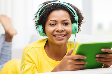 Image showing happy african woman with tablet pc and headphones