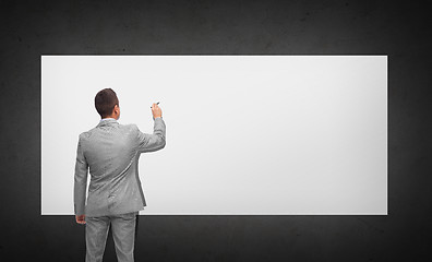 Image showing businessman writing or drawing on white board