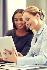 Image showing smiling businesswomen with tablet pc in office