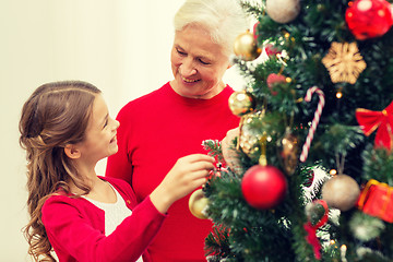 Image showing smiling family decorating christmas tree at home