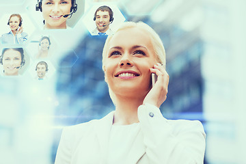 Image showing smiling businesswoman with smartphone outdoors