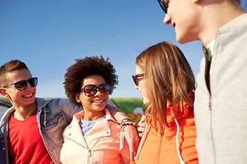 Image showing happy teenage friends in shades talking on street