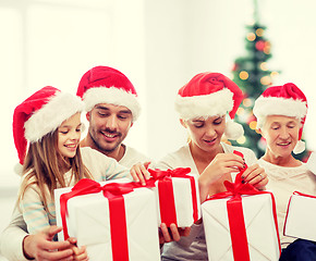 Image showing happy family in santa helper hats with gift boxes