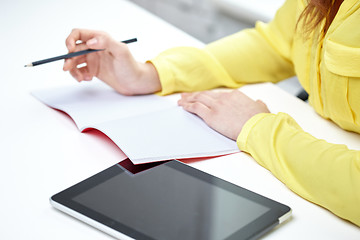 Image showing close up of woman with tablet pc and notebook