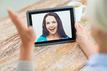 Image showing senior woman with photo on tablet pc at home