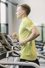 Image showing smiling man exercising on treadmill in gym