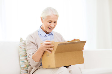 Image showing happy senior woman with parcel box at home