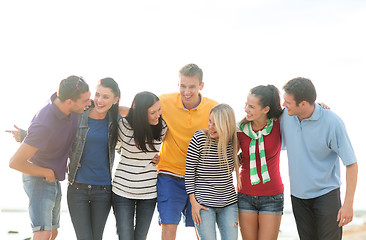 Image showing group of happy friends talking on beach