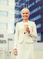 Image showing smiling businesswoman with paper cup outdoors