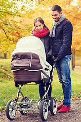 Image showing smiling couple with baby pram in autumn park