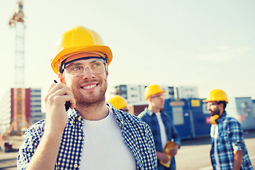 Image showing group of smiling builders in hardhats with radio