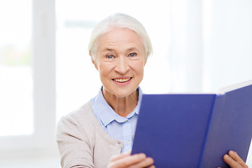 Image showing happy smiling senior woman reading book at home