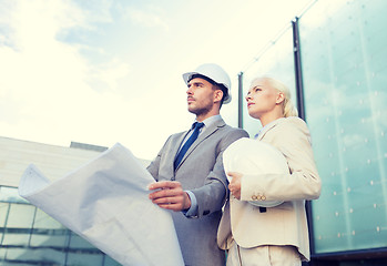 Image showing businessmen with blueprint and helmets