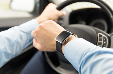 Image showing close up of man with wristwatch driving car