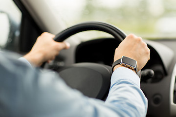 Image showing close up of man with wristwatch driving car