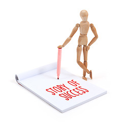 Image showing Wooden mannequin writing - Story of success