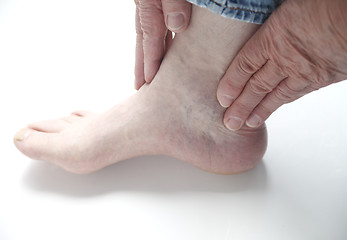 Image showing man with hands on ankle	