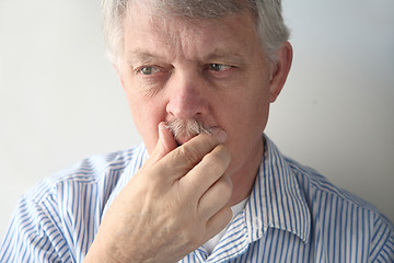 Image showing Senior man strokes his mustache.  