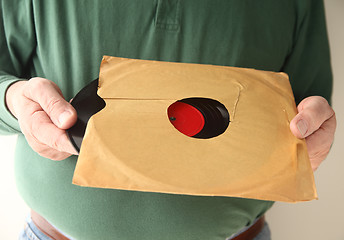 Image showing removing old vinyl record from sleeve